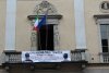 Lo striscione posto sulla facciata di Palazzo Ala Ponzone